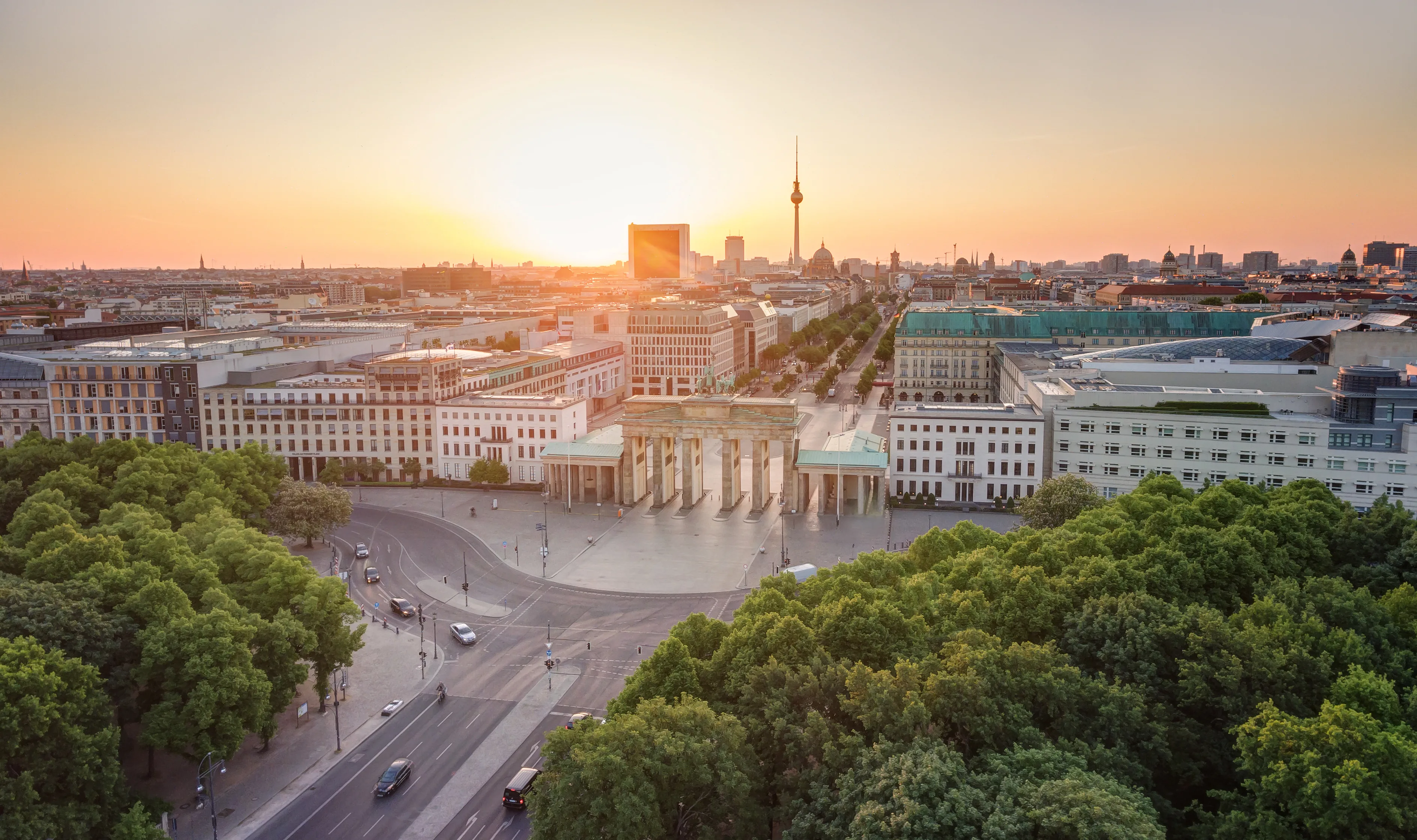 Blick über das Brandenburger Tor auf die Berliner Innenstadt bei Sonnenaufgang